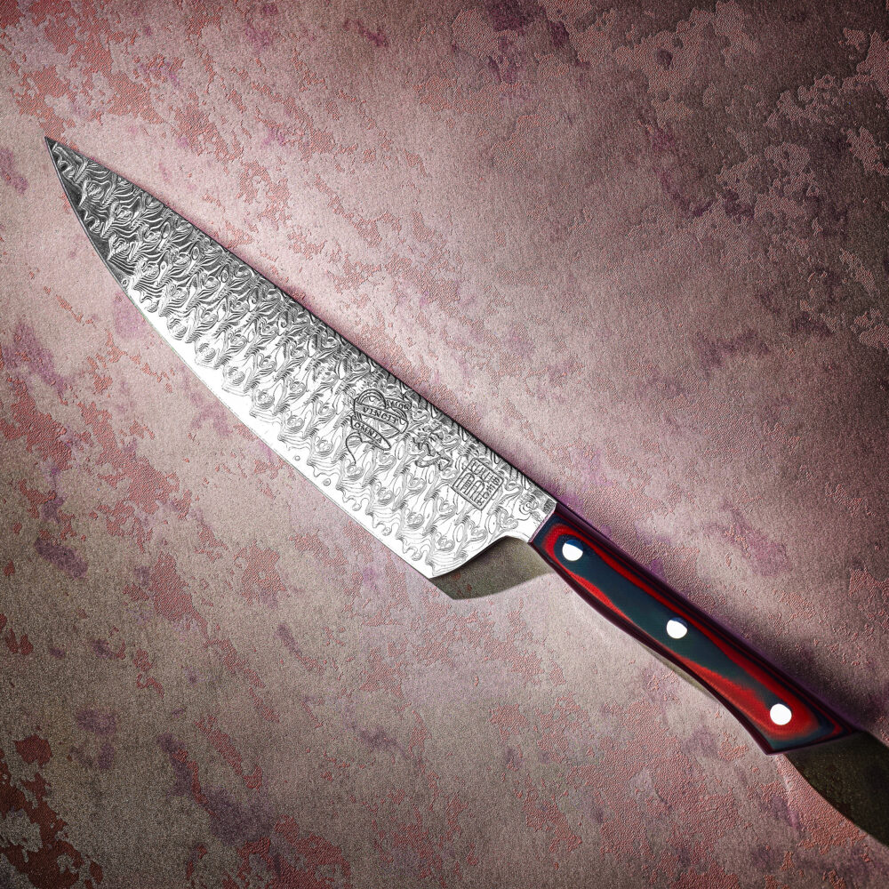 AMOR II Damascus chef's knife with a patterned blade and red and black handle.