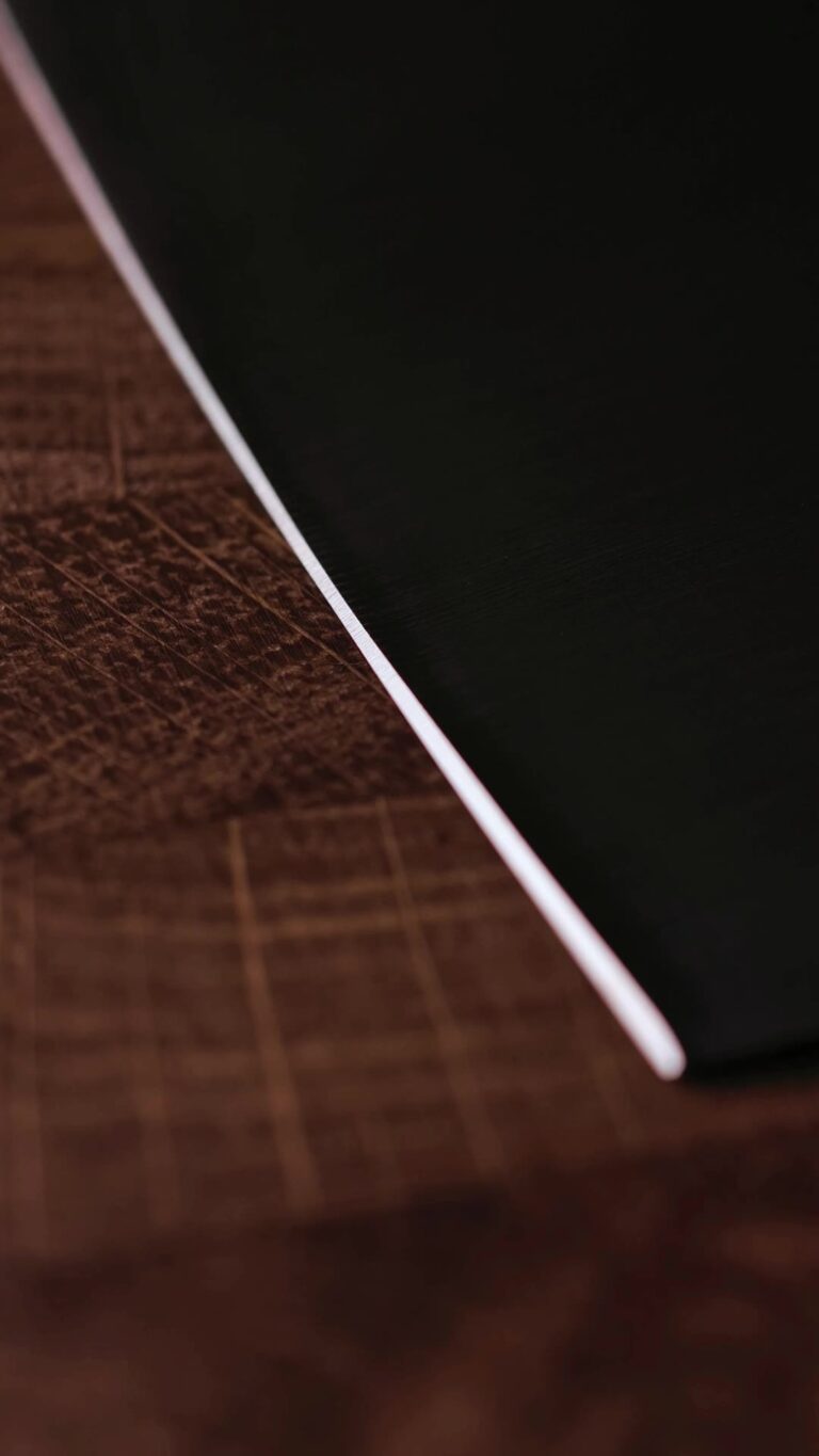 The edge of the RAW OAK THOR cleaver resting on an end-grain oak board.