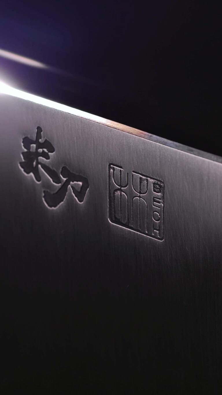 Light running along the spine of the RAW OAK THOR cleaver, with the mark visible on the stainless steel.