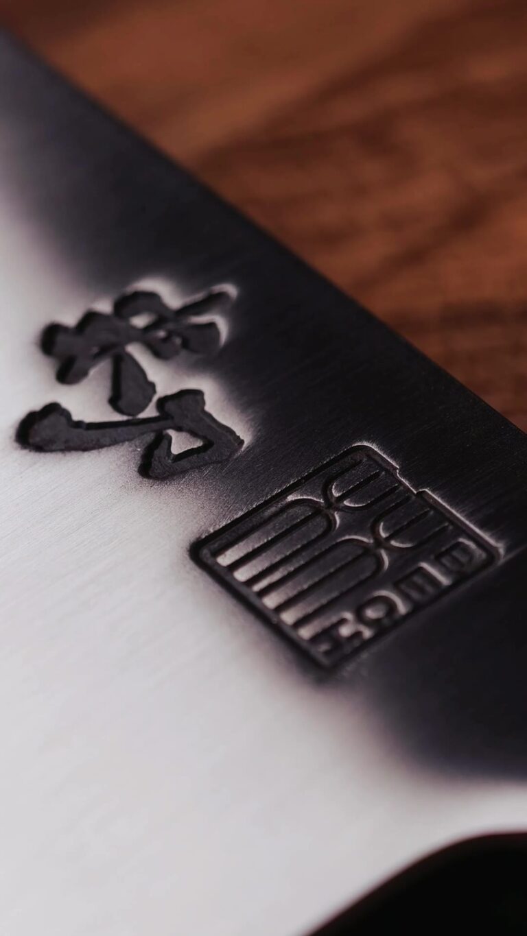 Close-up of the mark on the RAW OAK THOR cleaver blade, lit from the side.