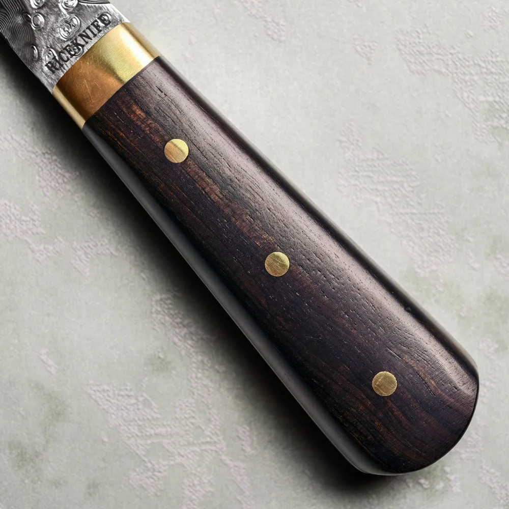 Ebony handle close-up with three brass-coloured pins